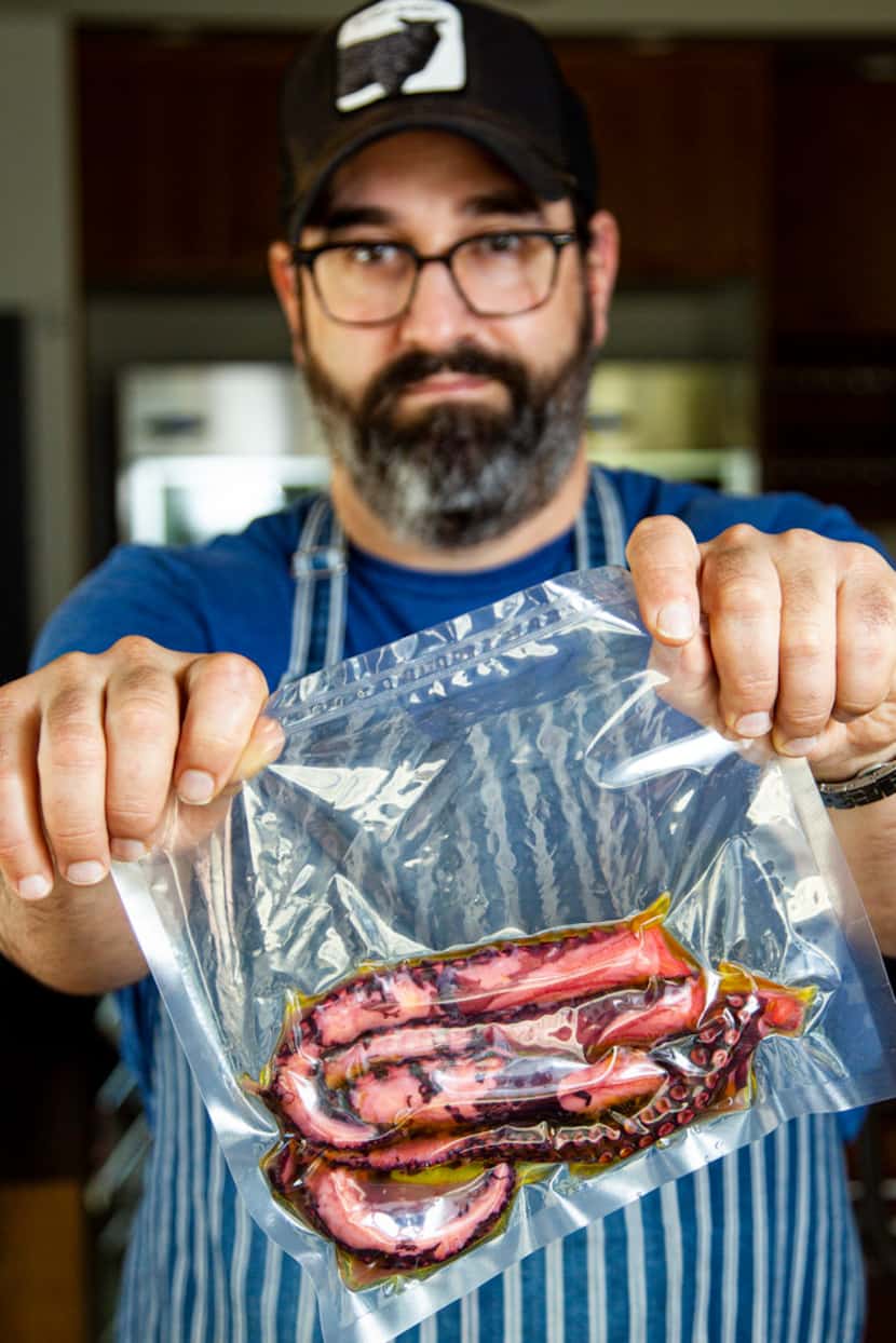 David Uygur shows octopus tentacles in a vacuum-sealed sous vide bag at his restaurant,...