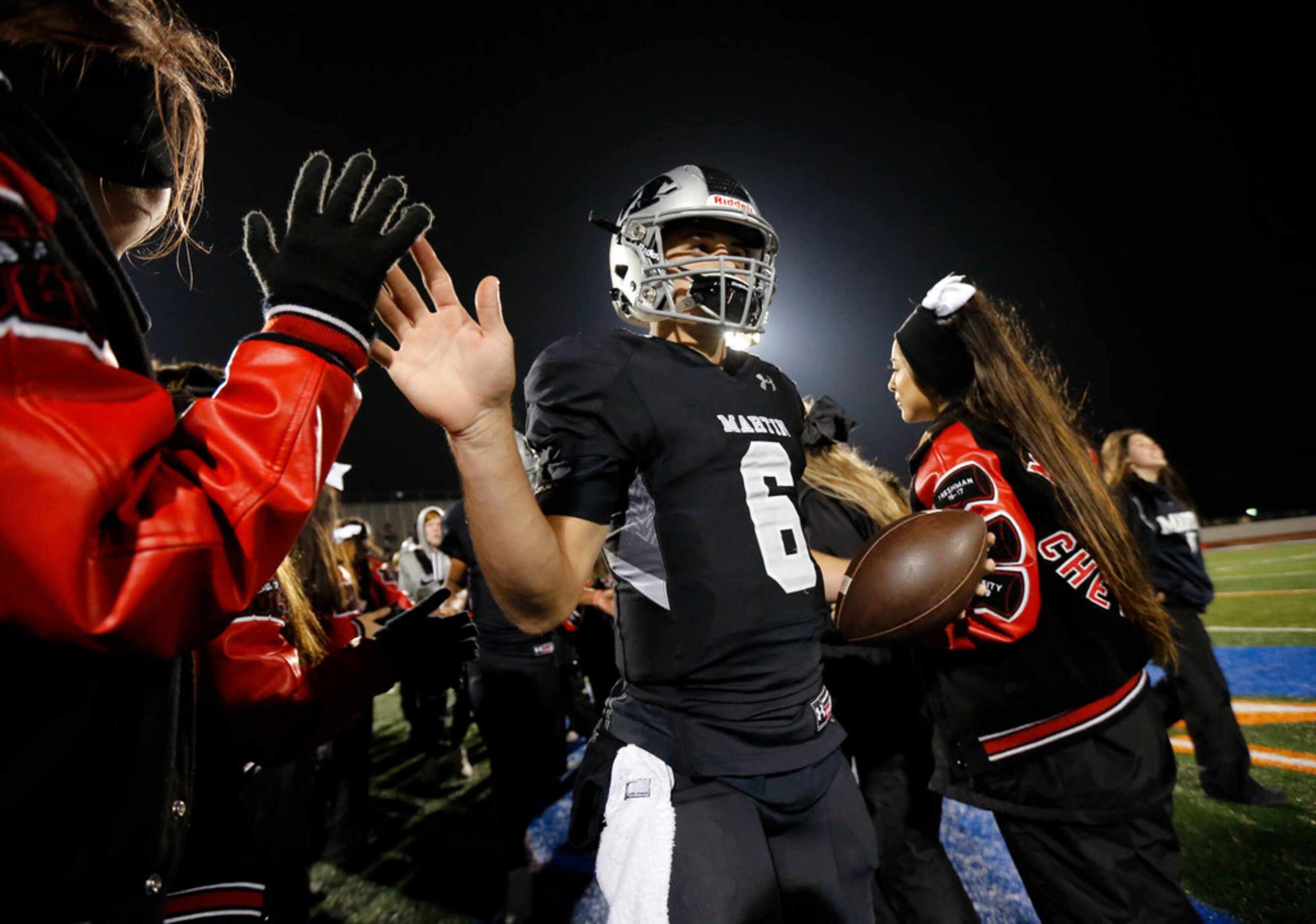Martin quarterback Zach Mundell (6) is congratulated by cheerleaders after their District...