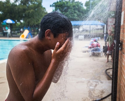 Lifeguard Moises Zambrano rinses off after swimming laps while working at the Bonnie View...