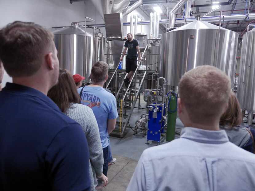 Aric Hulsey, on ladder, gives a tour of the brewery at the Community Beer Company Open House...