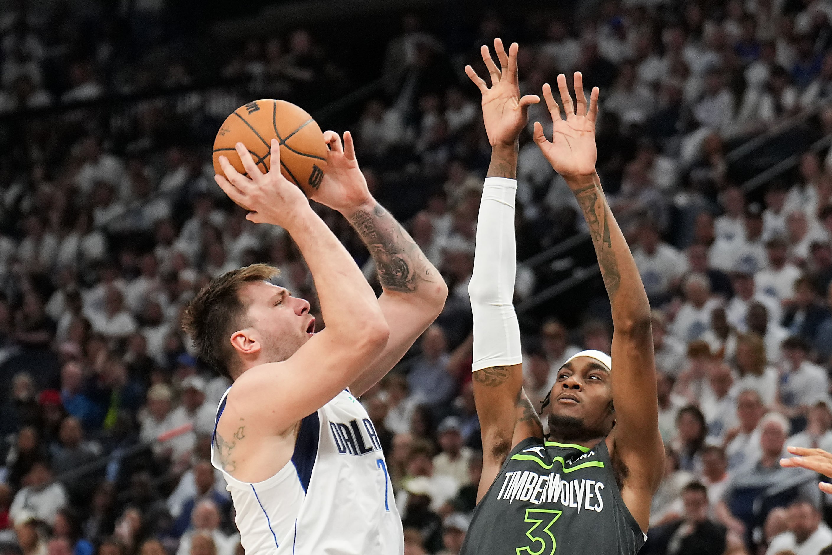 Dallas Mavericks guard Luka Doncic (77) shoots over Minnesota Timberwolves forward Jaden...