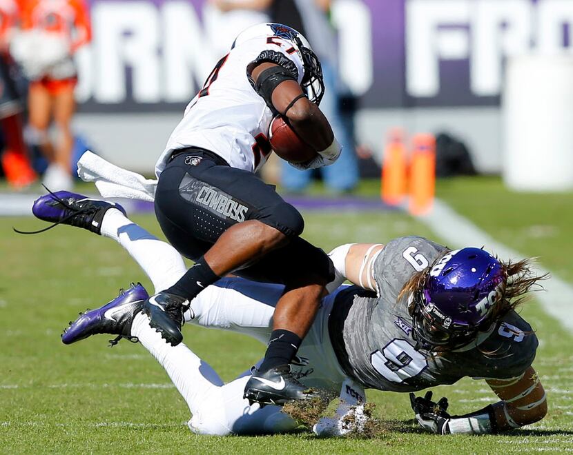 TCU Horned Frogs defensive end Mat Boesen (9) upends Oklahoma State Cowboys running back...