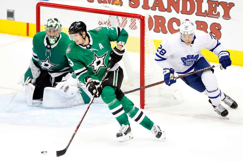 Dallas Stars defenseman John Klingberg (3) carries the puck up ice as he skates away from...