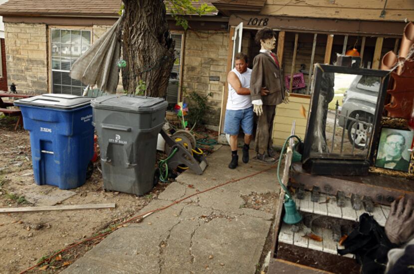 Ralph Granado carries a Halloween decoration to its spot on the front lawn of his Oak Cliff...