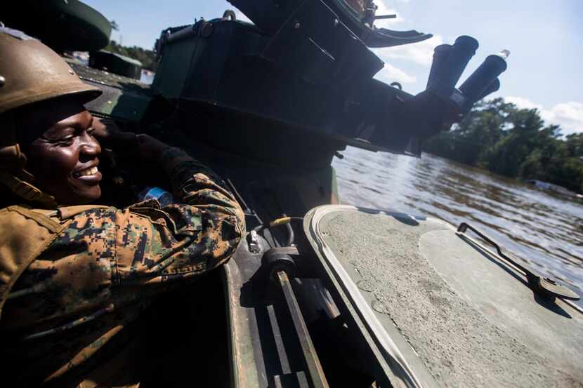 Navy Medic Gayakpa Komi rides with Marines and members of a swift water rescue task force...