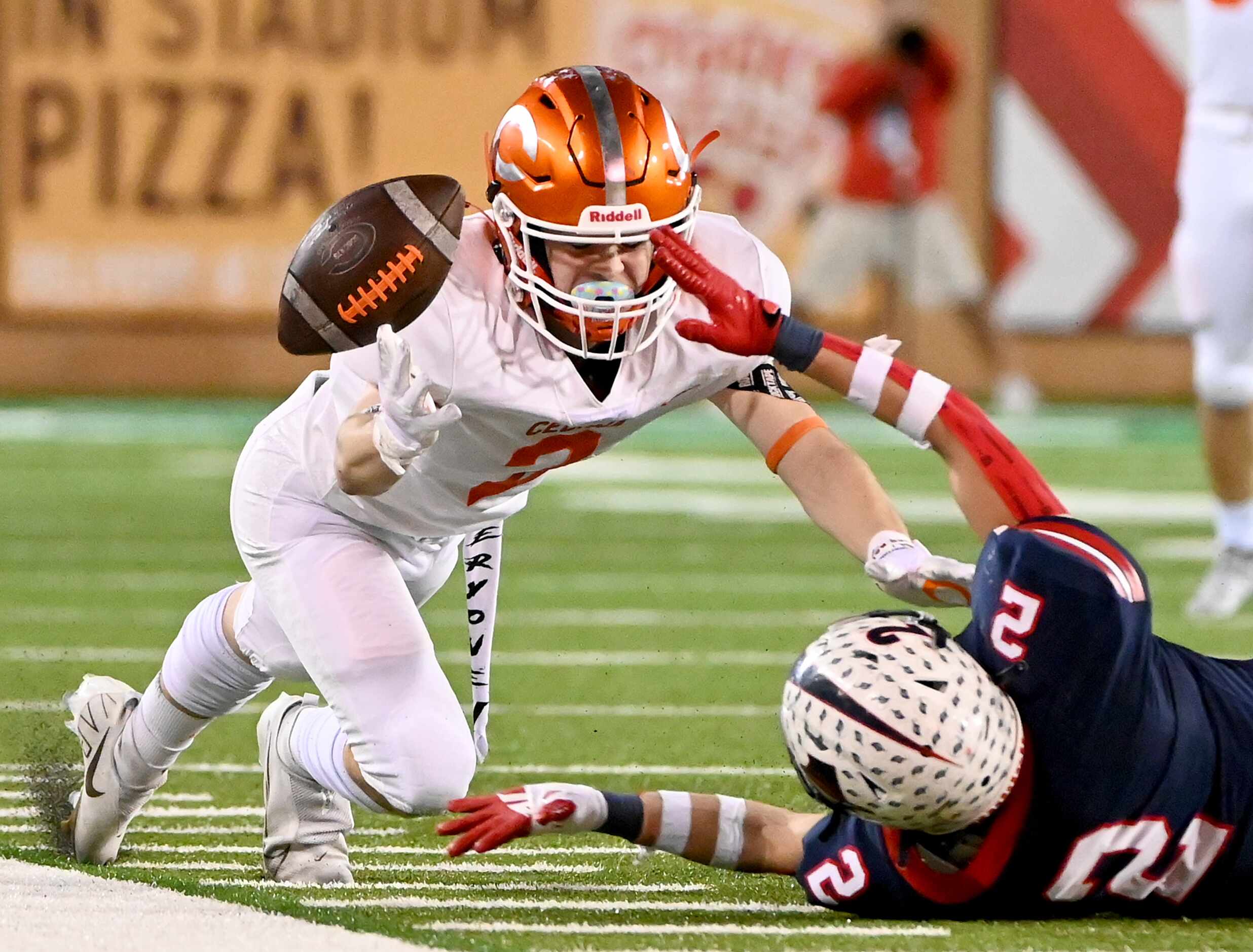 Celina's Collin Urich (2) can’t hold onto a pass as he’s defended by Aubrey's Kai Bagley (2)...