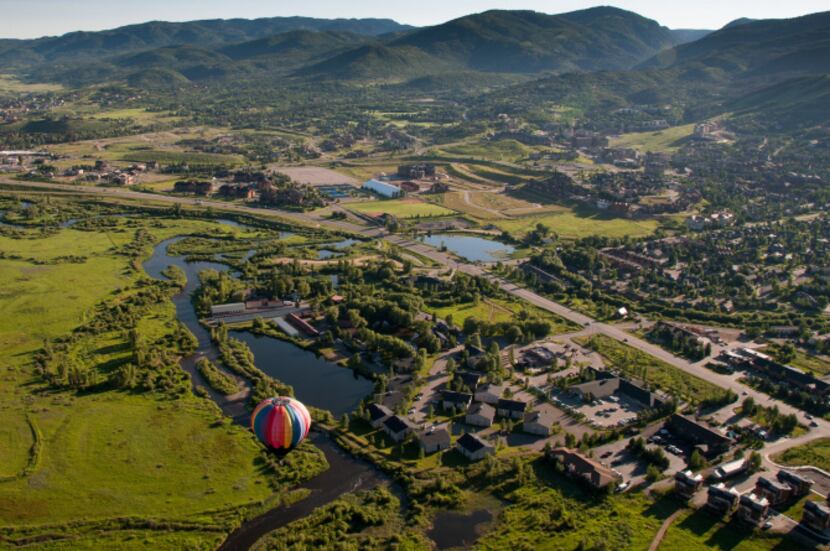 A balloon floats above Steamboat Springs.  Onboard, passengers gaze down on the city and...