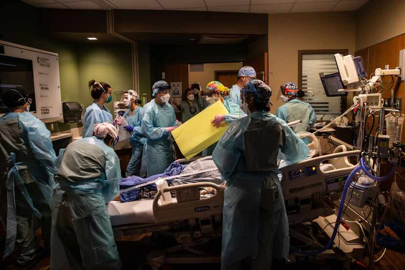 Más de una docena de profesionales médicos ayudan a intubar a un paciente con covid-19 para...