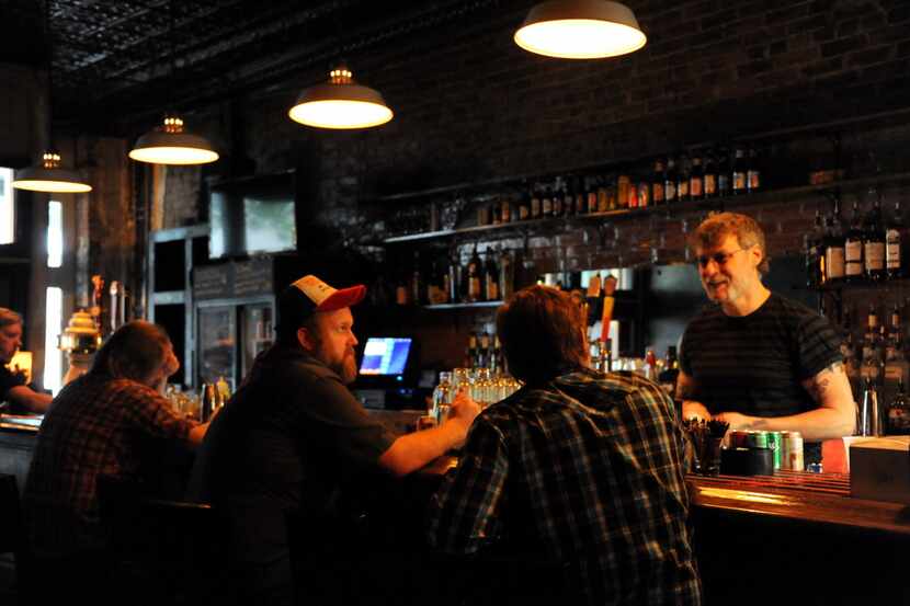 Patrons chat with the bartender on a Saturday evening at Eight Bells Alehouse in Expo Park...
