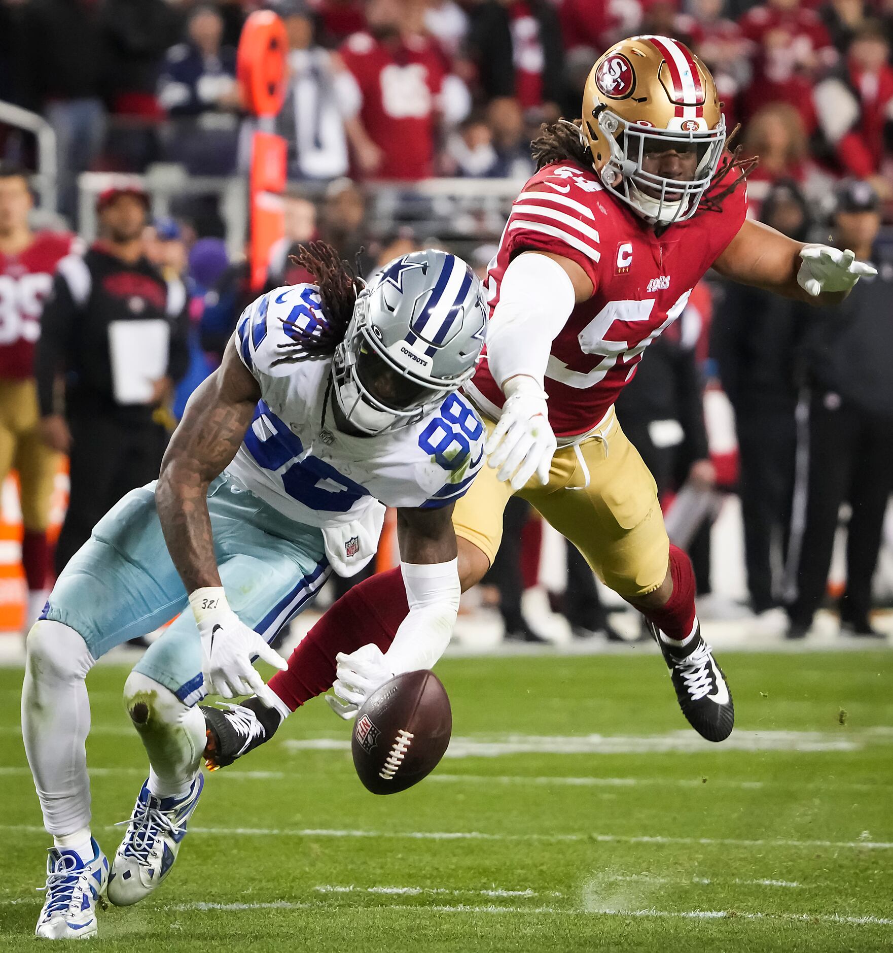 San Francisco 49ers linebacker Fred Warner (54) is tackled by Dallas  Cowboys wide receiver CeeDee Lamb after intercepting a pass during the  first half of an NFL divisional round playoff football game