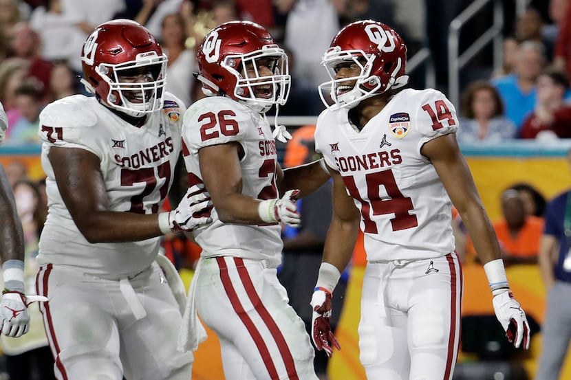 Oklahoma offensive lineman Bobby Evans (71) and running back Kennedy Brooks (26)...
