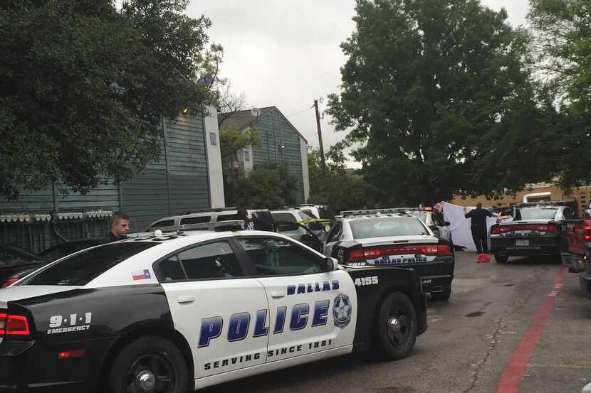 Policías de Dallas cubren un cuerpo sin vida mientras lo sacan de un auto en los...