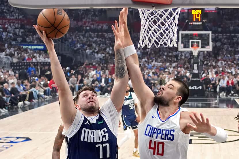 Dallas Mavericks guard Luka Doncic, left, shoots as Los Angeles Clippers center Ivica Zubac...