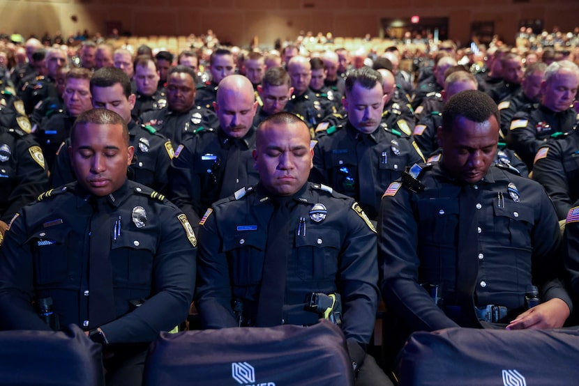 Members of the Garland Police Department bow their heads during the funeral services for...