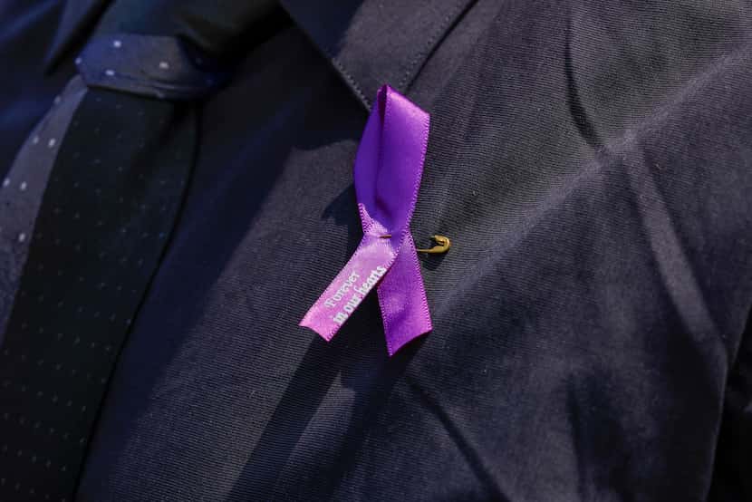 Purple domestic violence ribbons that read “forever in our hearts” were worn at the...