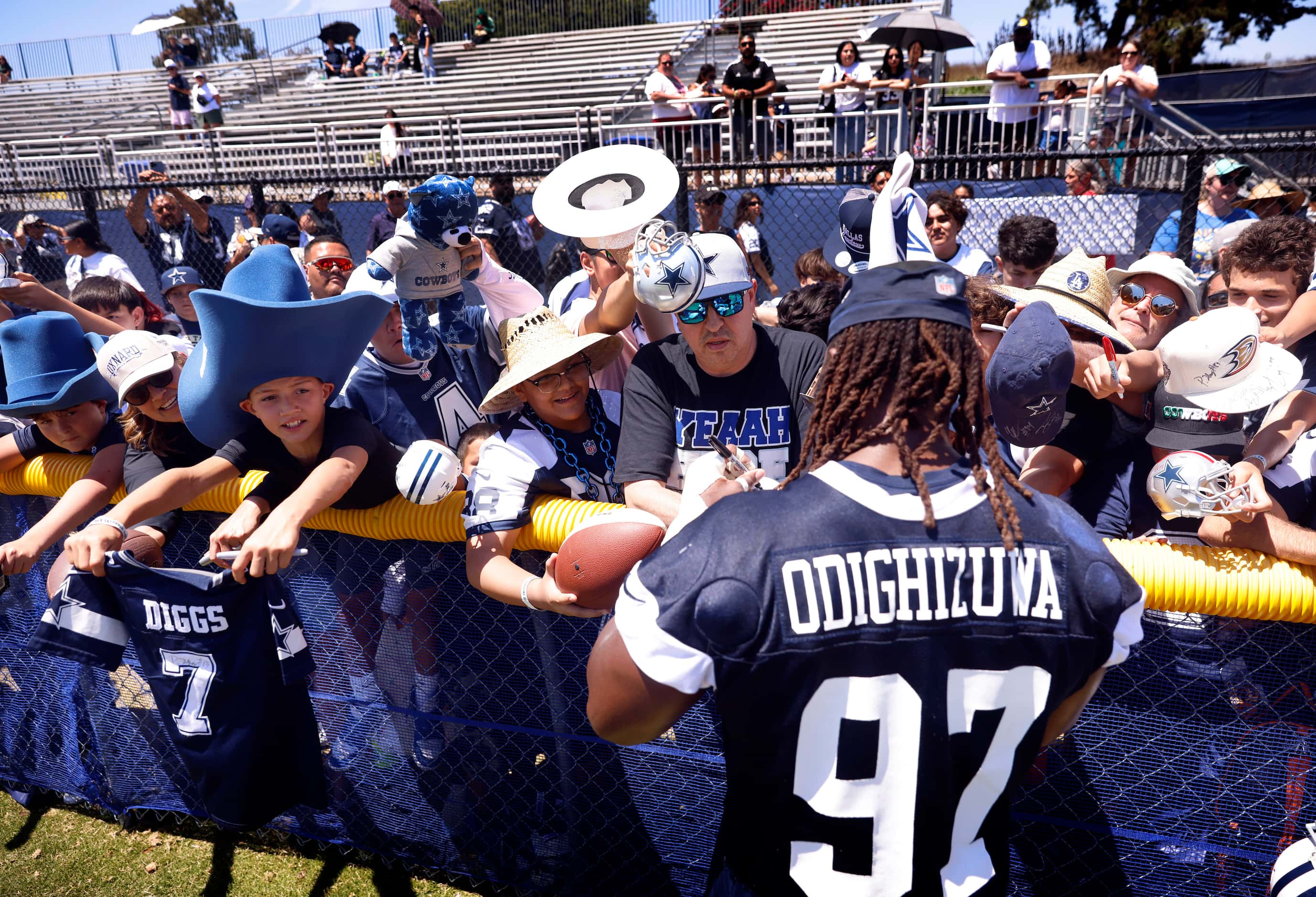 Dallas Cowboys defensive tackle Osa Odighizuwa (97) signs autographs for fans following...