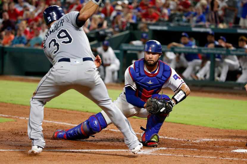 Texas Rangers catcher Isiah Kiner-Falefa, right,prepares to tag out Tampa Bay Rays' Kevin...