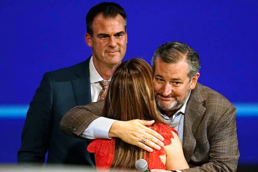U.S. Sen. Ted Cruz, right, embraces Oklahoma first lady Sarah Stitt, left, as Oklahoma Gov....