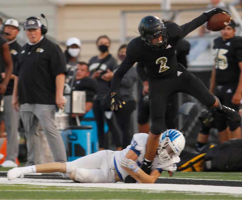 Kaufman receiver Daylon Dickerson (2) stretches for extra yardage as he is tackled by...