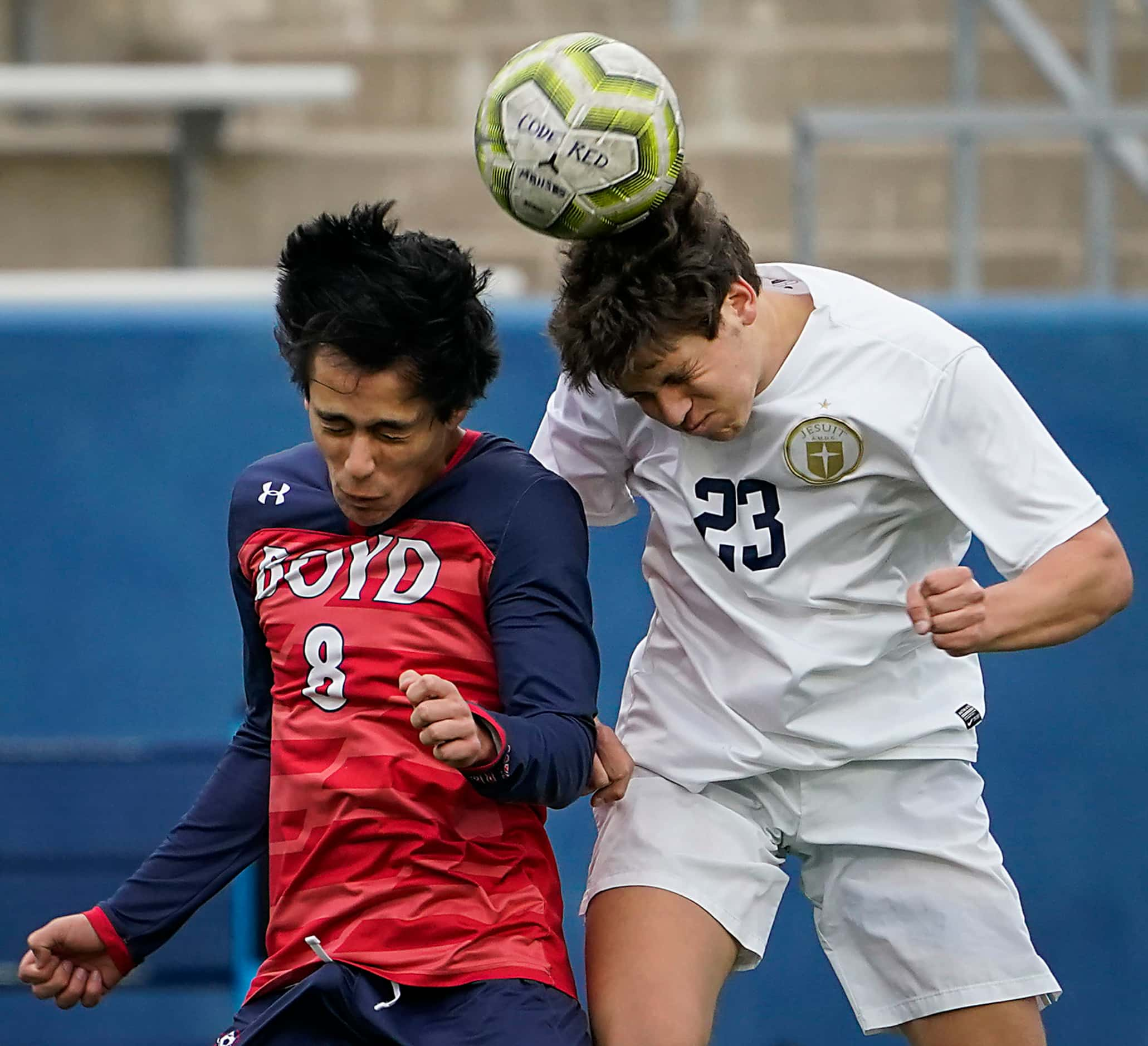 Jesuit midfielder Zach Poen (23) wins a header against McKinney Boyd midfielder Daniel Ortiz...