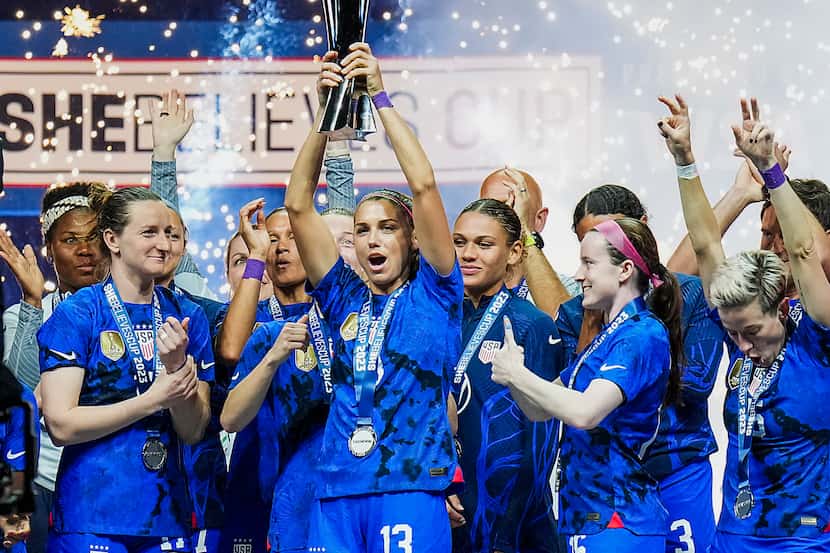 United States forward Alex Morgan (13) raises the trophy after a victory over Brazil in the...