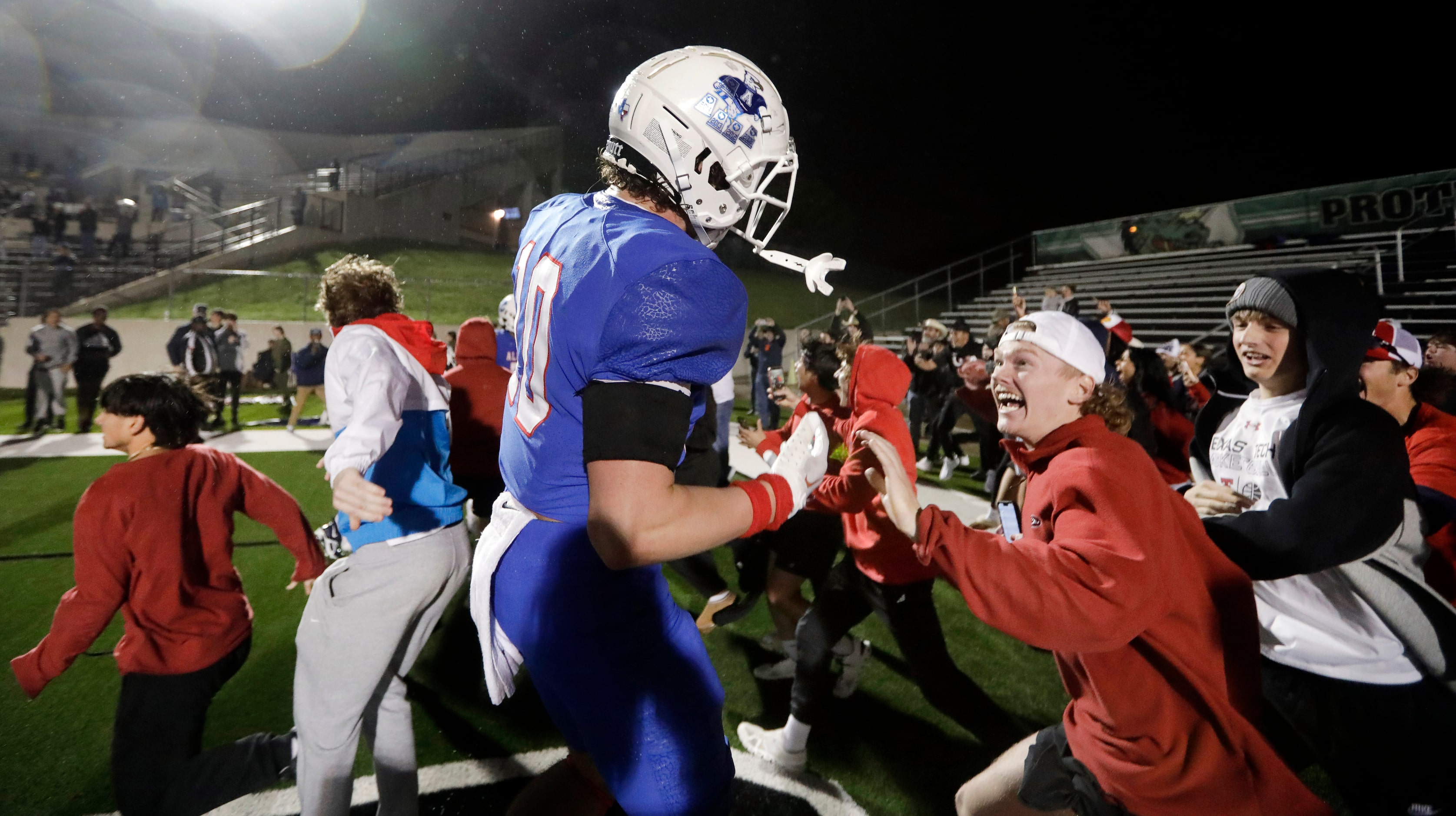 The Allen student section pours into the end zone after they defeated Arlington Martin on a...