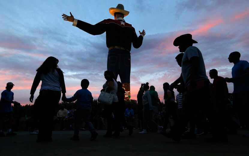 As the sun sets on the last day of the State Fair of Texas, fairgoers pass through Big Tex...