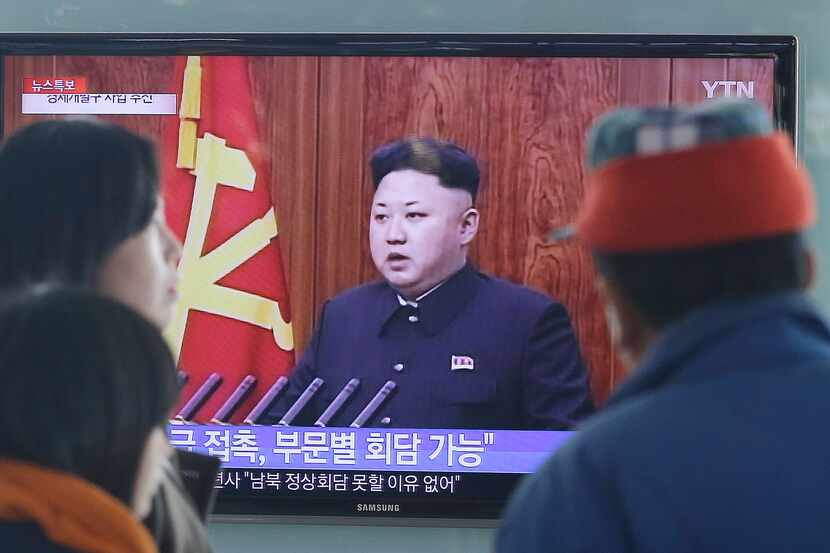 People watch a TV news program showing North Korean leader Kim Jong-Un delivering a speech,...