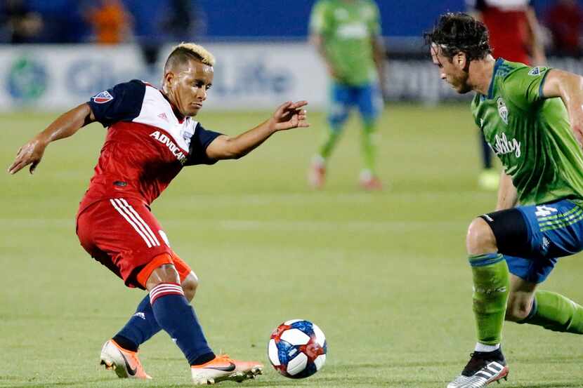 FC Dallas midfielder Michael Barrios (21) makes a move to get past Seattle Sounders defender...