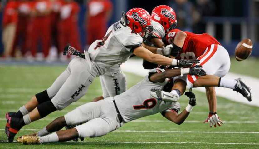 Cedar Hill's Richard Moore (4) and Darrell Miller (9) force a fumble from Katy running back...