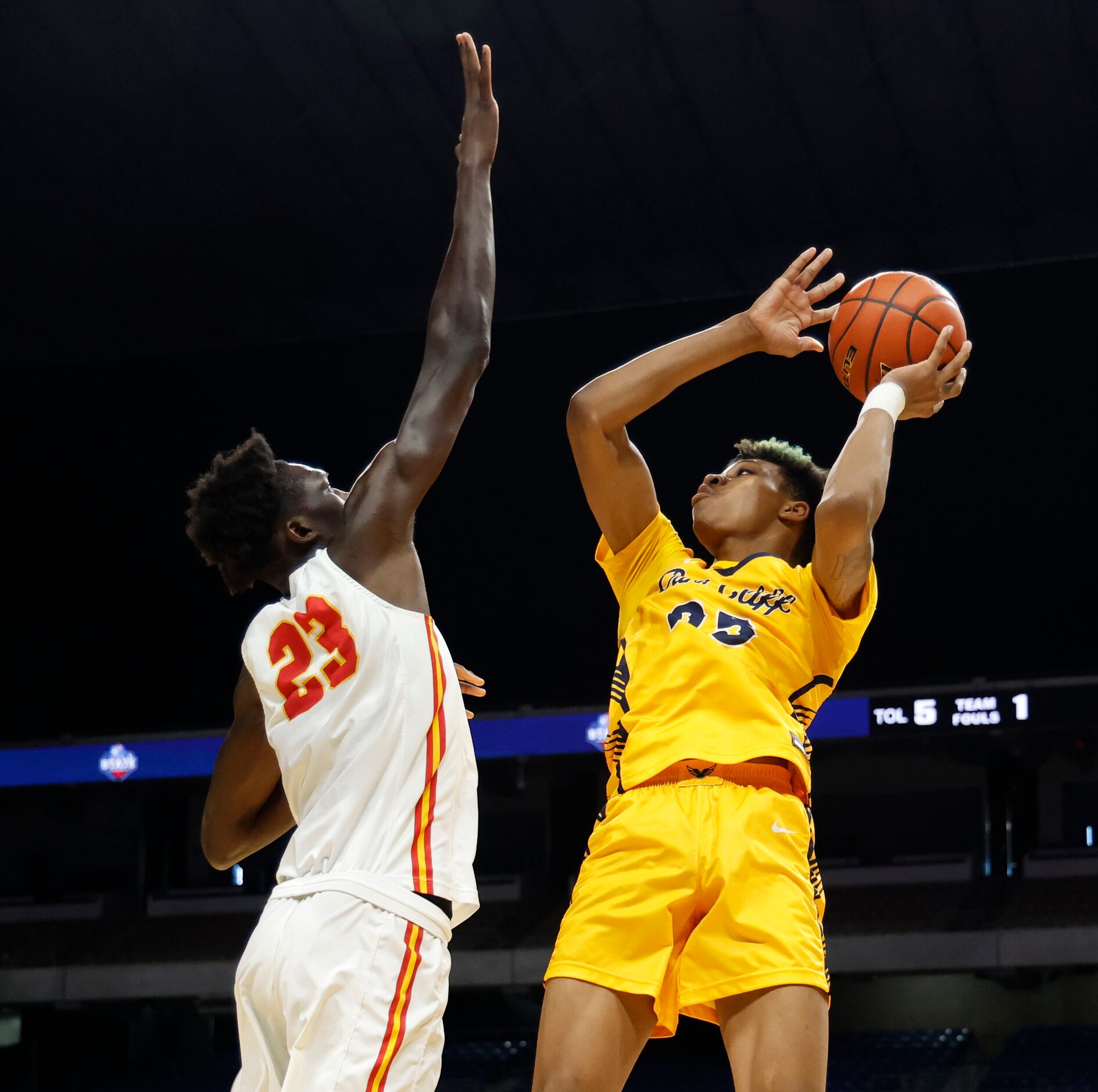 Faith Family's Davion Adkins (25) shots over Stafford's Dame Salane (23) in the first half...