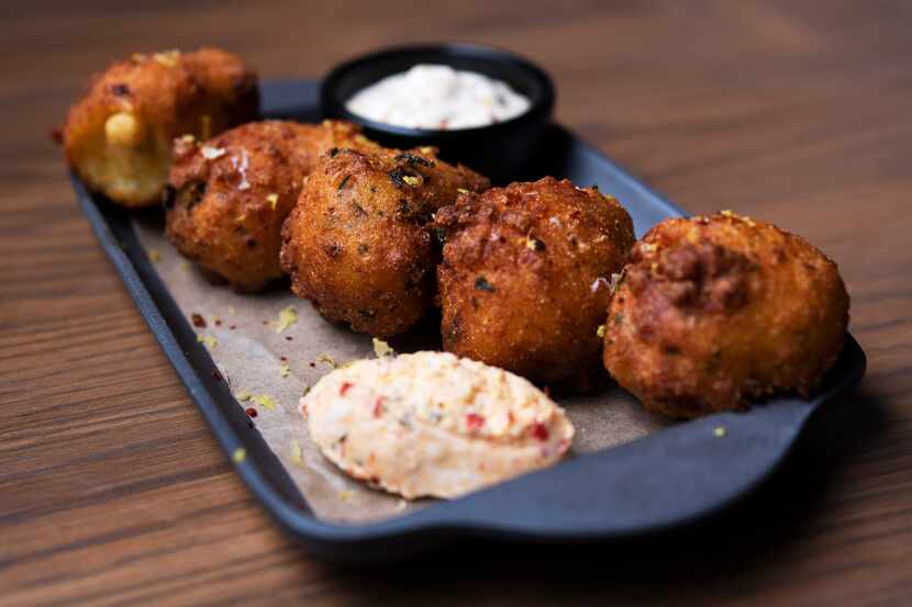 East Texas hush puppies with charred okra, pimento cheese and cajun remoulade sauce are on...