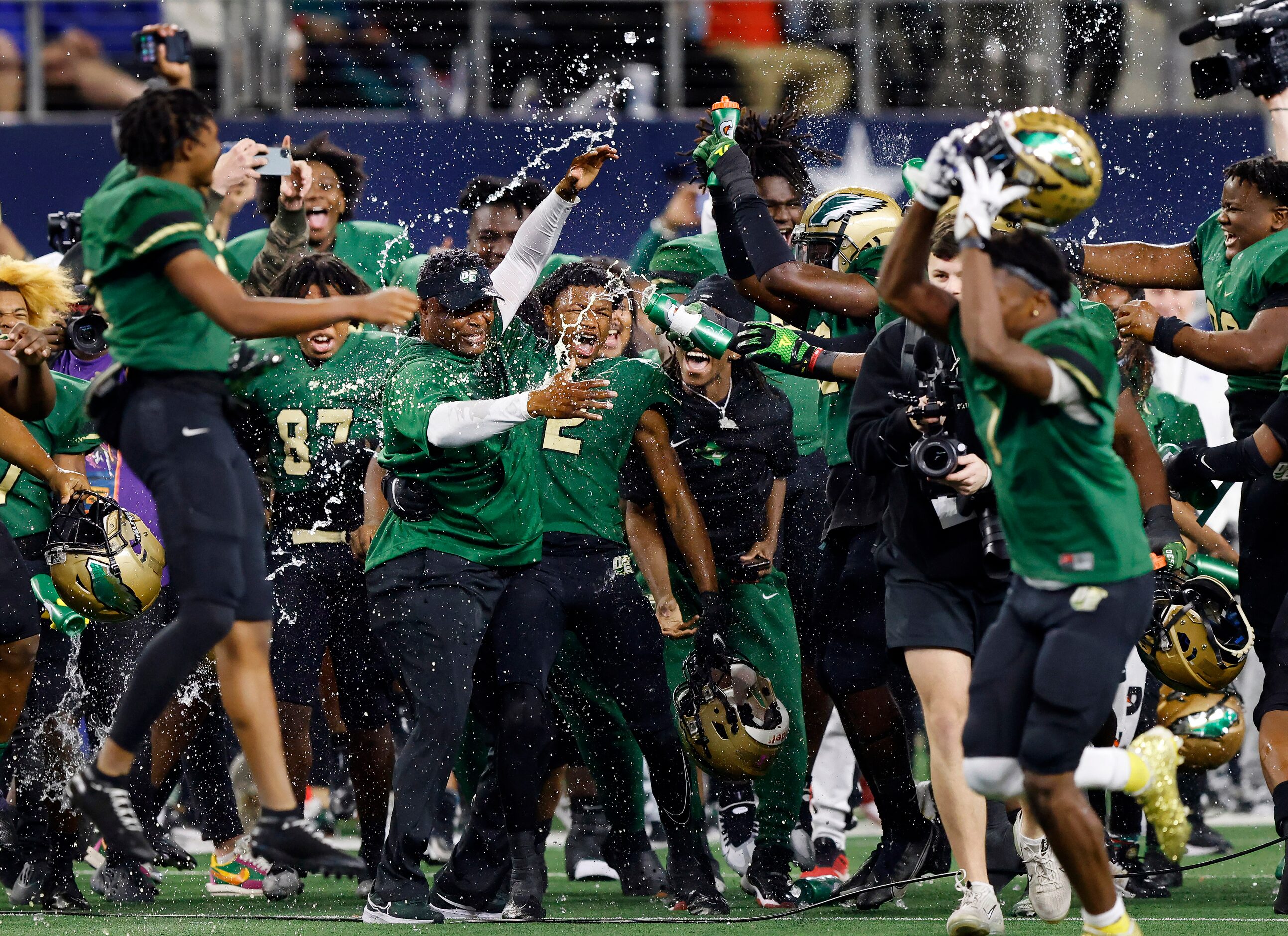 DeSoto head coach Claude Mathis is doused with water bottles by his players after a victory...