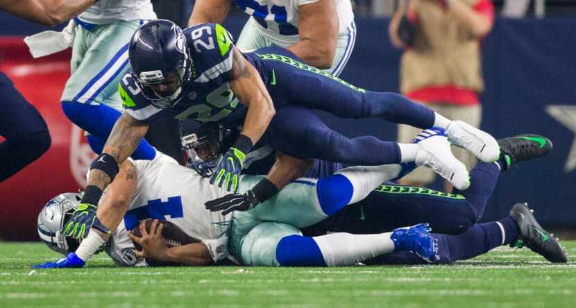 Dallas Cowboys quarterback Dak Prescott (4) is sacked by Seattle Seahawks free safety Earl...