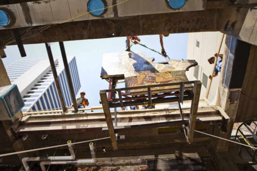 A team of riggers and Balfour Beatty construction men guide a mosaic into the...
