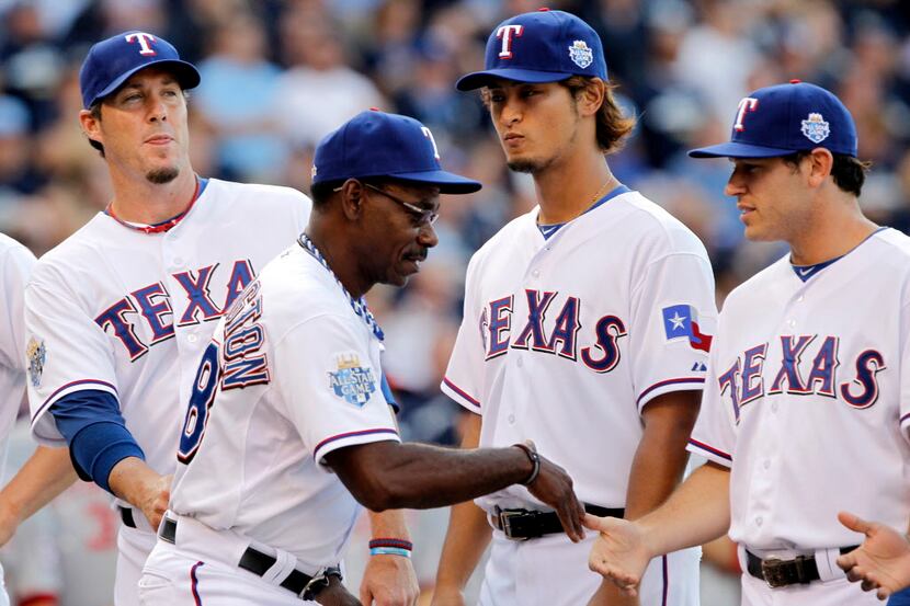 American League manager Ron Washington (38) slaps hands with fellow members of the Texas...