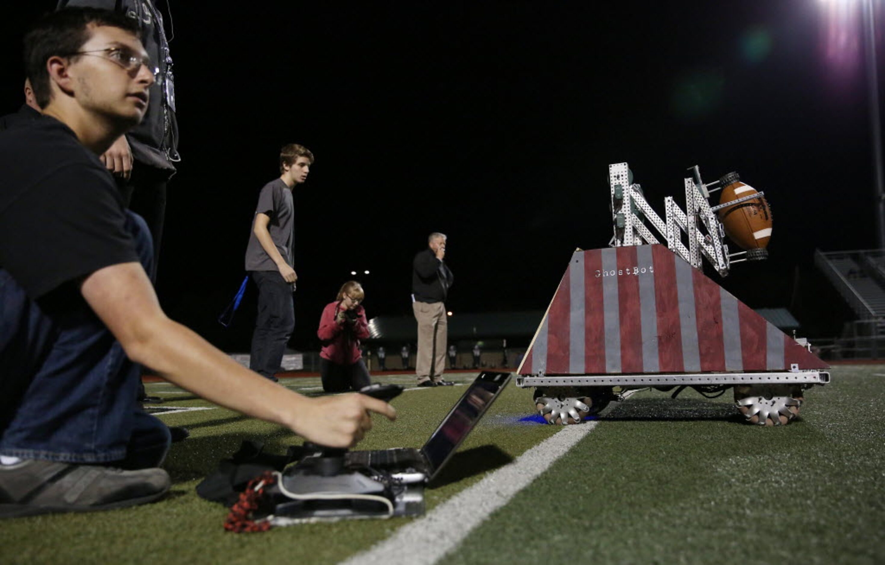 Jacob Jeter (left), 16, of the Waxahachie Robotics team, controls Dead Mouse, a robot...