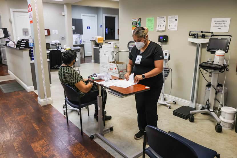 Felicia Rodriguez checks a patient's paperwork Aug. 2 at the Agape Clinic in Old East Dallas.