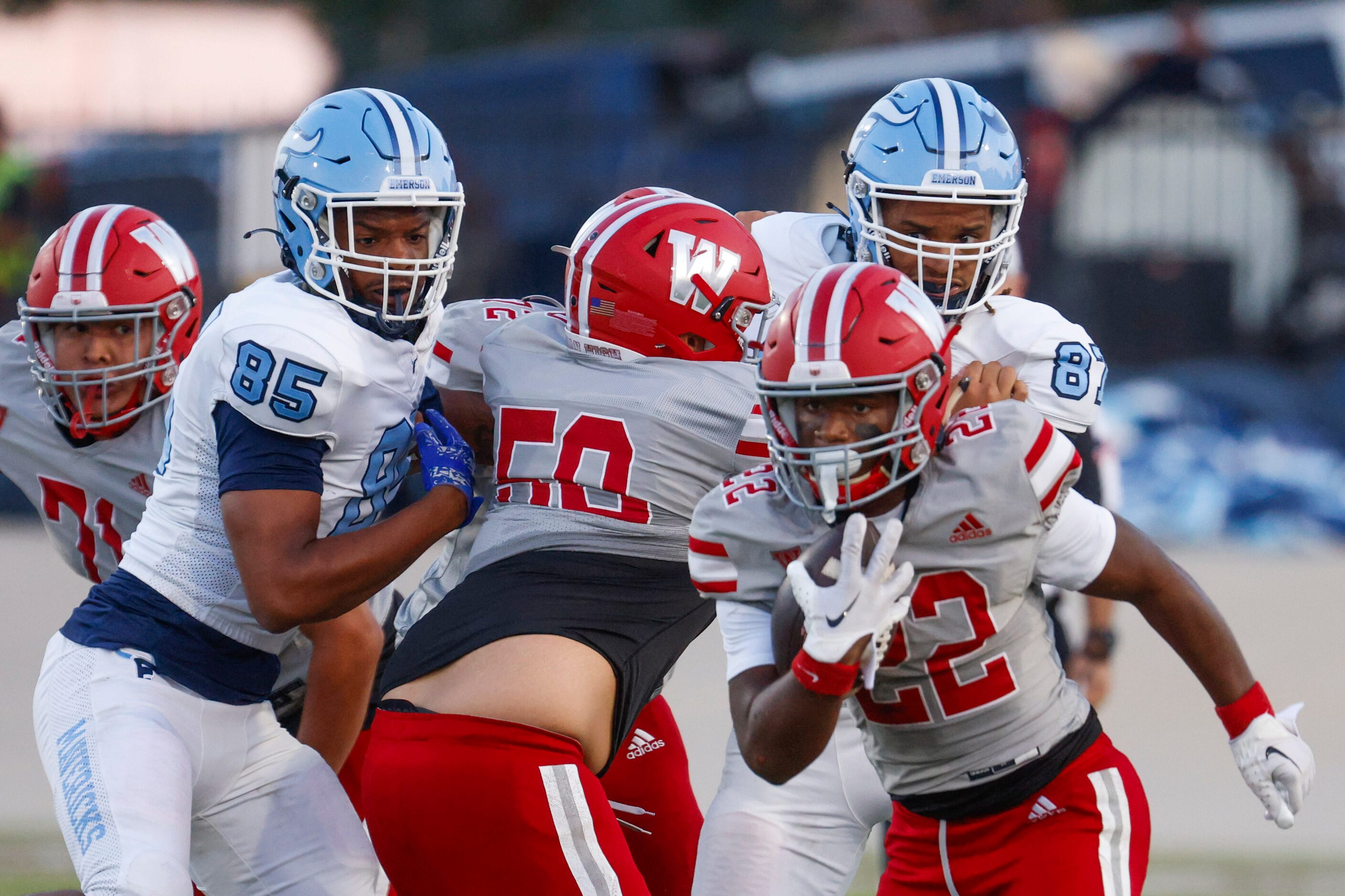 Woodrow Wilson’s CJ McGuire (front right) runs with the ball past Emerson High School’s...