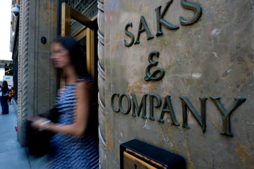 FILE- In this July 29, 2013, file photo, a shopper uses a Fifth Avenue entrance to Saks, in...