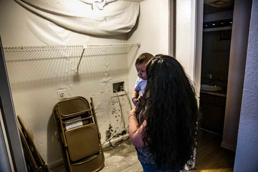 María Magarin, con su bebé en brazos, muestra el moho que ya se ha formado en su apartamento...