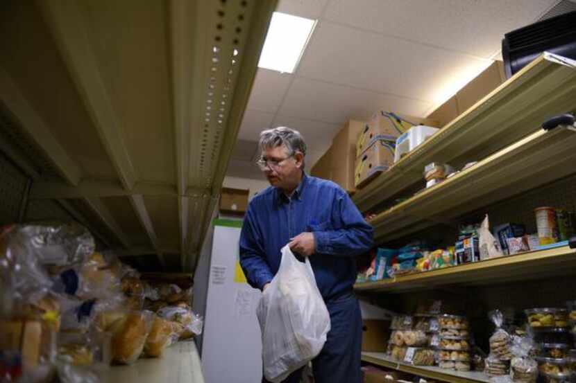 
Volunteer Richard Coffey helps distribute food at the Cedar Hill Food Pantry on Jan. 3,...