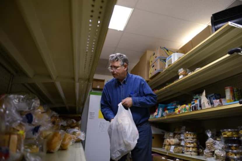 
Volunteer Richard Coffey helps distribute food at the Cedar Hill Food Pantry on Jan. 3,...