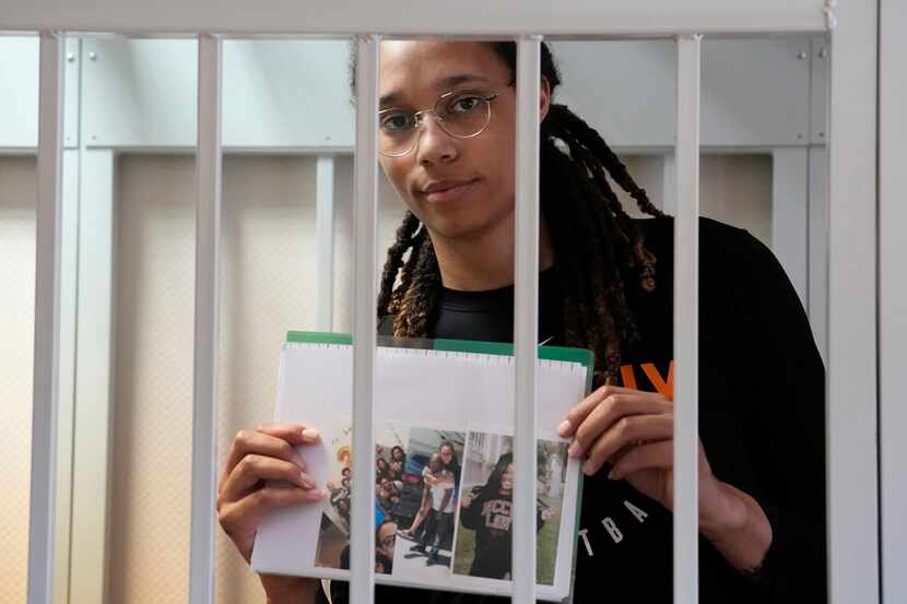 WNBA star and two-time Olympic gold medalist Brittney Griner holds images standing in a cage...