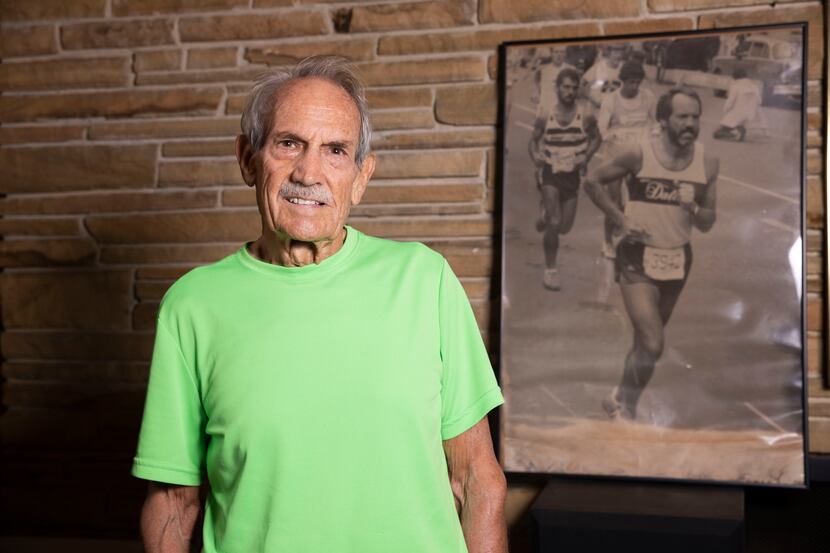 James Thruston, 84, poses in front of a photo of him running the 1981 New York Marathon on...