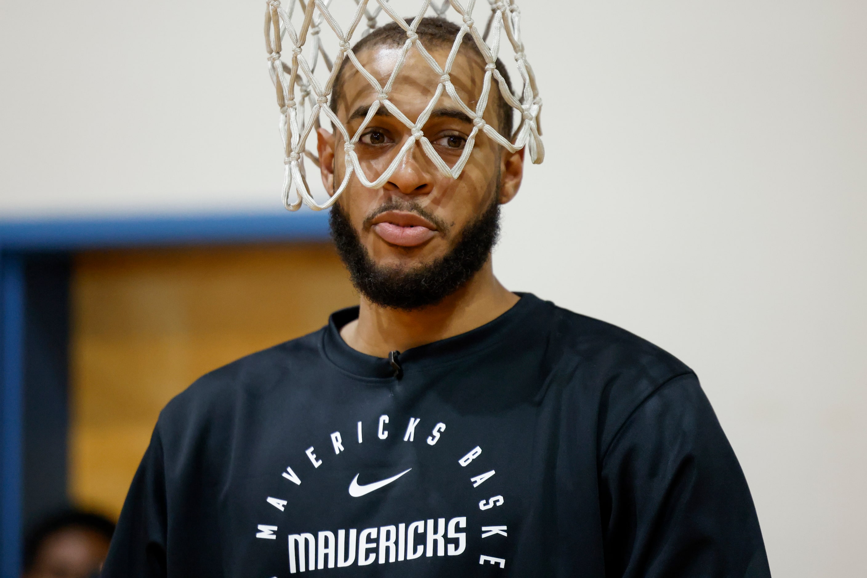 Dallas Mavericks center Daniel Gafford stands in the net of a lowered basketball hoop during...