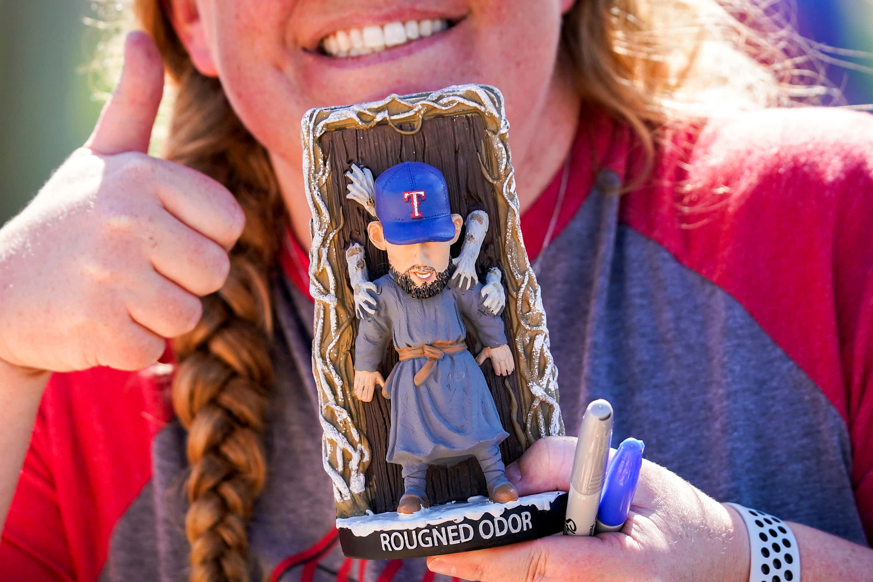 A fan shows off a bobble head of Texas Rangers second baseman Rougned Odor while waiting for...