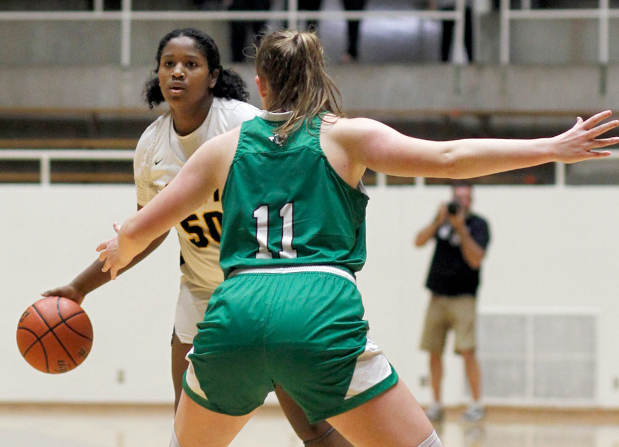 Plano East forward Taylor Haggan (50) brings the ball to the top of the key as she is...