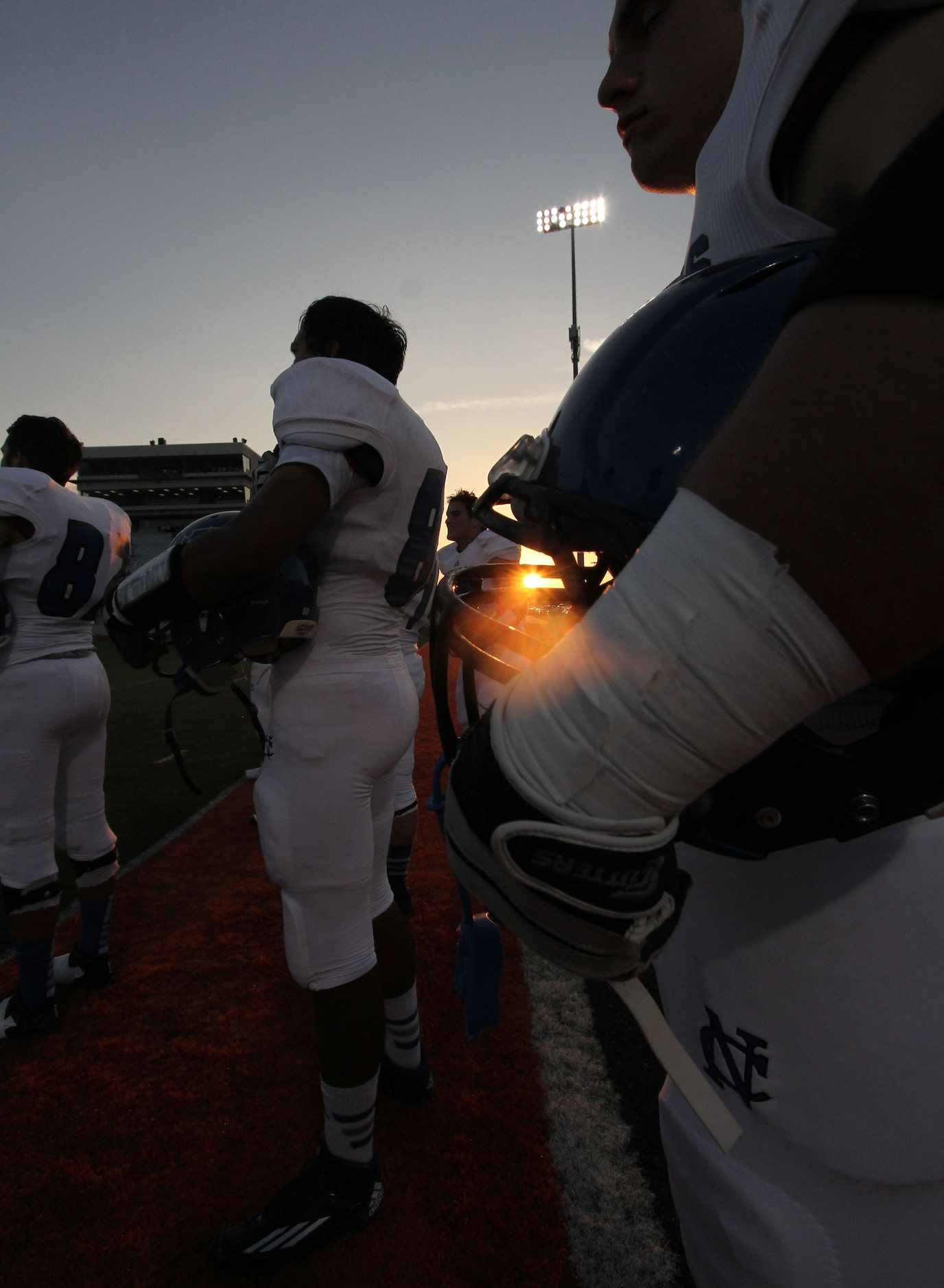 Fort Worth Nolan players stand at attention as the sun sets during the playing of the...