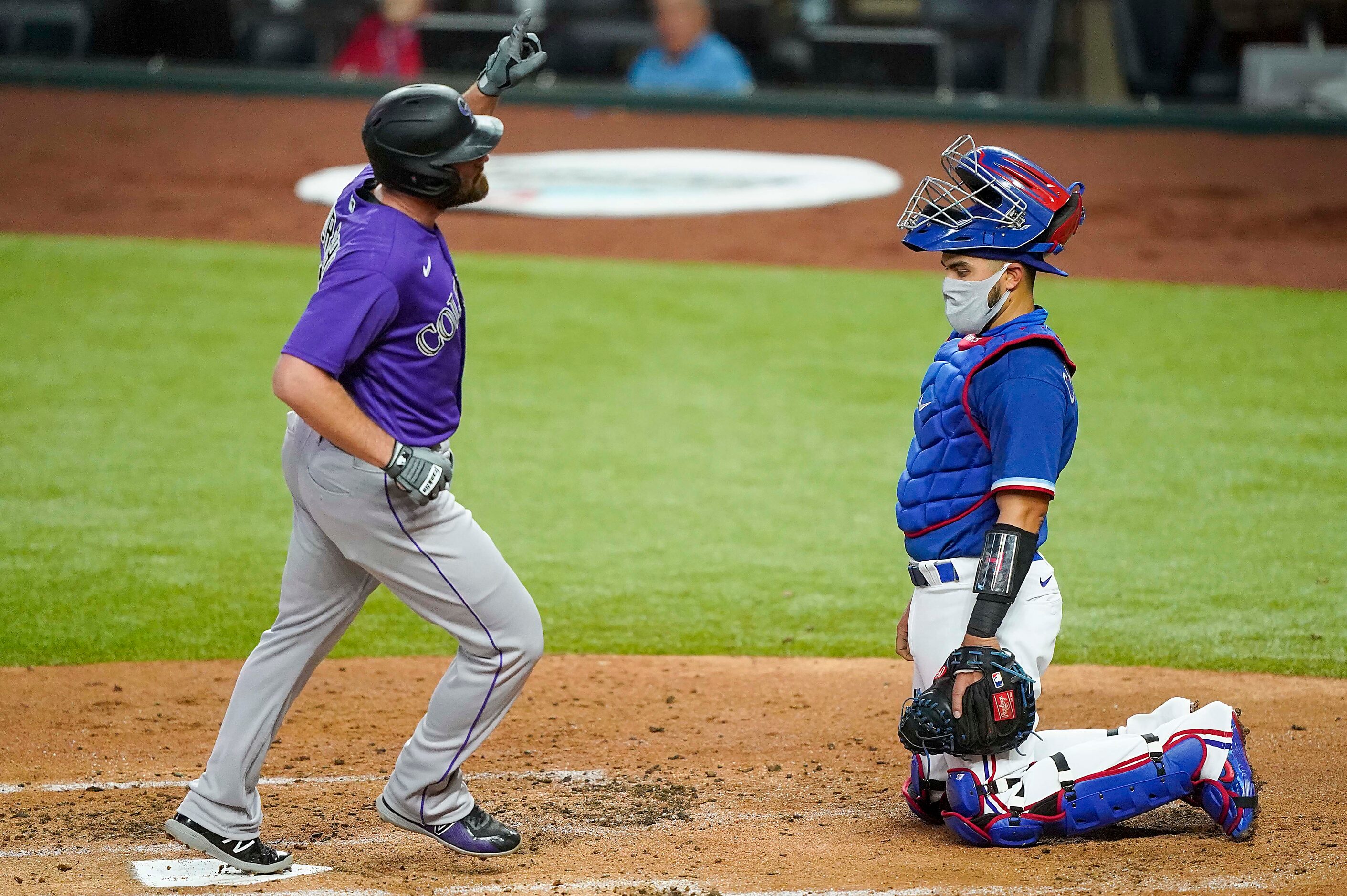 Texas Rangers catcher Robinson Chirinos watches as Colorado Rockies first baseman Daniel...